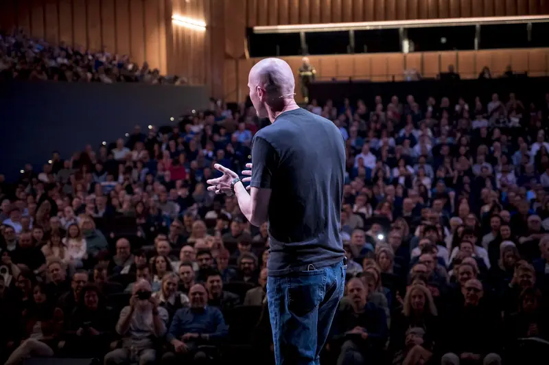 Marco “Monty” Montemagno di spalle sul palco, davanti al pubblico di Bologna